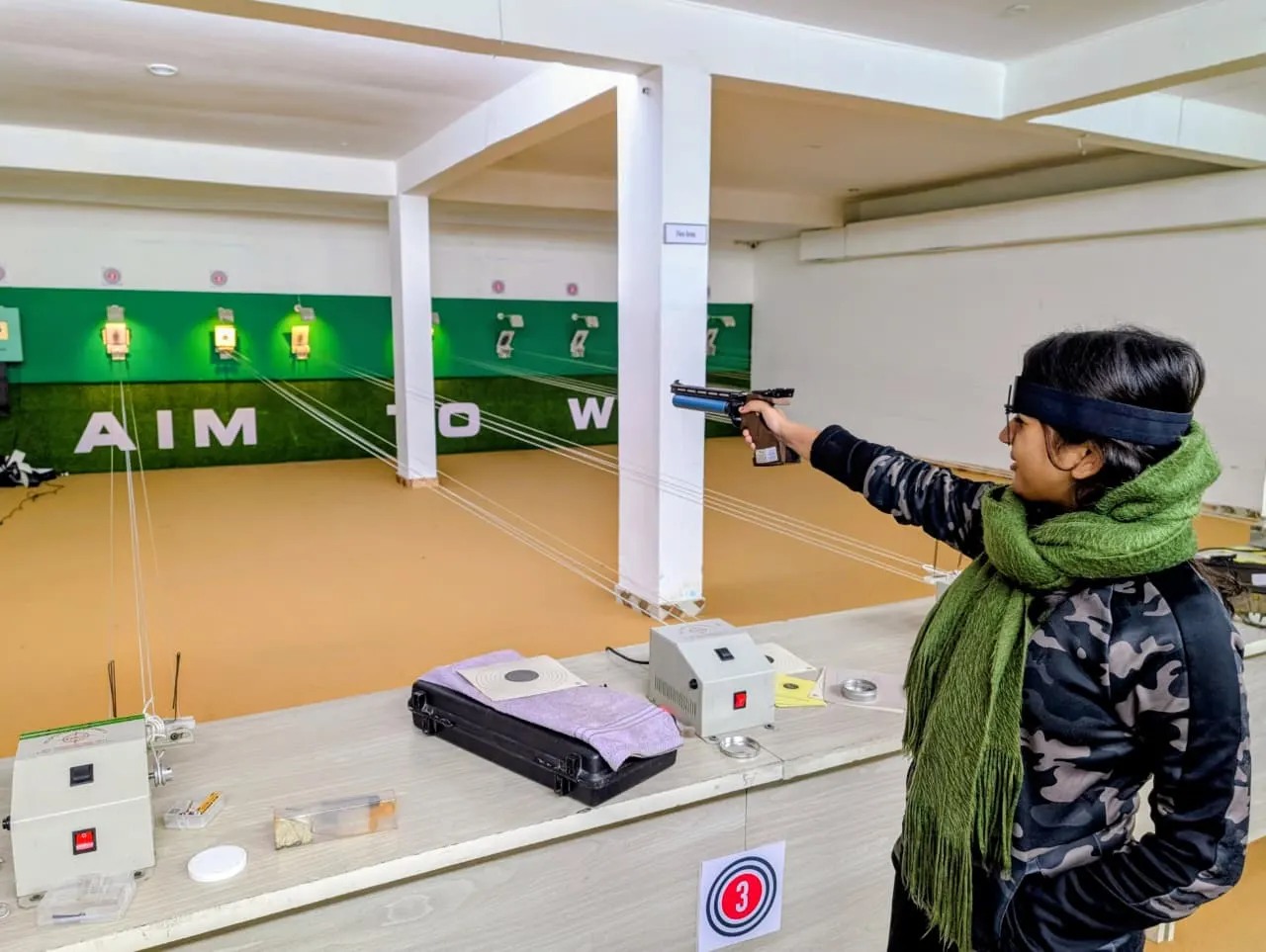 Shooter taking aim with a 10m air pistol on the range